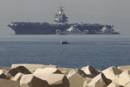 FILE - In this Thursday, March 29, 2012 file photo, a small boat pass in front of the aircraft carrier USS Enterprise is seen anchored of the coast of Faliro, near Athens. The U.S. Navy said Monday, April 9, 2012 that it has deployed a second aircraft carrier to the Persian Gulf region amid rising tensions with Iran over its nuclear program. The deployment of the nuclear-powered USS Enterprise along the Abraham Lincoln carrier strike group marks only the fourth time in the past decade that the Navy has had two aircraft carriers operating at the same time in the Persian Gulf and the Arabian Sea, said Cmdr. Amy Derrick-Frost of the Bahrain-based 5th Fleet. (AP Photo/Petros Giannakouris, File)