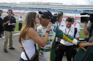 La reportera Lauren Bohlander besa al piloto brasileño Tony Kanaan después de que éste ganó la pole para la Indy 300 de Las Vegas, el viernes 14 de octubre de 2011, en Las Vegas. (Foto AP/Isaac Brekken)