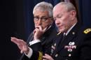 Defense Secretary Chuck Hagel listens at left as Joint Chiefs Chairman Gen. Martin E. Dempsey speaks during a briefing at the Pentagon, Thursday, Oct. 30, 2014. (AP Photo/Susan Walsh)