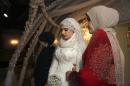 FILE- Saturday, May 16, 2015 file photo Chechen Kheda Goilabiyeva, second right, stands after her wedding with Chechen police officer Nazhud Guchigov, in Chechnya's provincial capital Grozny, Russia, Saturday, May 16, 2015. A 46-year-old Chechen police officer taking a 17-year-old as his second wife in flagrant violation of Russian laws has caused a storm in the Russian media and put the region's ruler on the defensive. (AP Photo, File)