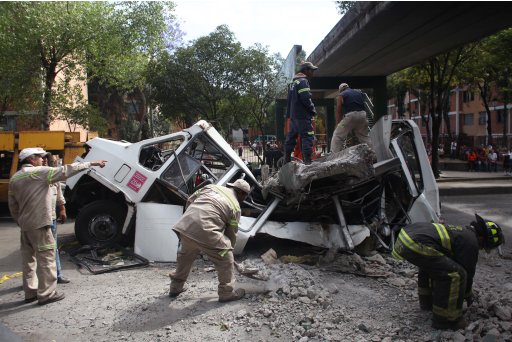 Firefighters work to remove a cement beam that fell from a bridge onto a public bus after an earthquake was felt in Mexico City Tuesday March 20, 2012. A strong 7.4-magnitude earthquake hit central and southern Mexico on Tuesday, collapsing at least 60 homes near the epicenter and a pedestrian bridge in the capital where people fled shaking office buildings in fear. There were no passengers in the mini-bus and the driver suffered minor injuries, according to firefighters. (AP Photo/Alexandre Meneghini)