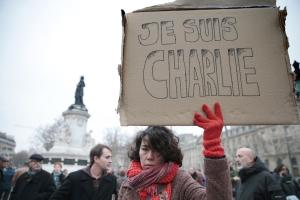 A woman holds up a placard that reads in French, &quot;I&nbsp;&hellip;