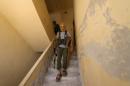 A Nusra Front fighter walks with his weapon inside a building in the Sheikh Maksoud neighbourhood of Aleppo