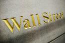 FILE - This Oct. 8. 2014, file photo, shows a Wall Street address carved into the side of a building in New York. U.S. stocks are opening the year on a strong note, but energy stocks slipped as the price of crude oil resumed its slide, Friday, Jan. 2, 2015. (AP Photo/Mark Lennihan, File)