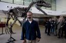 Argentine paleontologist Sebastian Apesteguia poses beside what he says is a replica of newly-discovered carnivorous dinosaur that lived in Argentina about 90 million discovered in Argentina's Patagonia in Buenos Aires, Argentina, Wednesday, July 13, 2016. The team of scientists says it was up to 26 feet long but its arms only measured about 2 feet. (AP Photo/Natacha Pisarenko)
