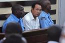 Tang Yong Jian (C), 40, a Chinese national, is arraigned in a Nairobi court January 27, 2014 after he was arrested for trying to smuggle 3.4 kg of raw elephant ivory through Kenya