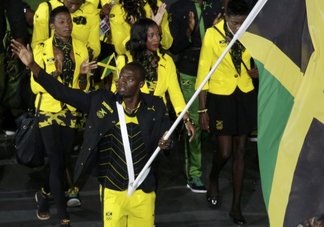 Jamaica's flag bearer Usain Bolt holds the national flag as he leads the contingent in the athletes parade during the opening ceremony of the London 2012 Olympic Games at the Olympic Stadium