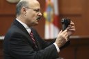 Assistant state attorney Bernie de la Rionda shows George Zimmerman's gun to the jury while presenting the state's closing arguments against Zimmerman during his trial in Seminole circuit court in Sanford, Fla. Thursday, July 11, 2013. Zimmerman has been charged with second-degree murder for the 2012 shooting death of Trayvon Martin. (AP Photo/Orlando Sentinel, Gary W. Green, Pool)
