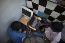 A resident reads emails at a makeshift internet cafe in front of the presidential palace in Port-au-Prince