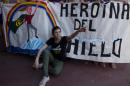 Argentine Greenpeace activist Camila Speziale poses in front of a banner reading "Heroine of the Ice" after arriving at Ezeiza International Airport in Buenos Aires on December 28, 2013 following 100 days in detention in Russia
