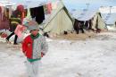 A Syrian child stands in the snow in a refugee camp in the town of Arsal in the Lebanese Bekaa valley on December 13, 2013