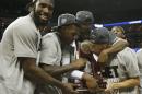 Florida guard Scottie Wilbekin, right, kisses the NCAA trophy standing with team mates after the second half in a regional final game against Dayton at the NCAA college basketball tournament, Saturday, March 29, 2014, in Memphis, Tenn. Florida won 62-52. (AP Photo/Mark Humphrey)