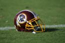 A Washington Redskins football helmet lies on the field during NFL football minicamp, Wednesday, June 18, 2014, in Ashburn, Va. The U.S. Patent Office ruled Wednesday, June 18, 2014, that the Washington Redskins nickname is "disparaging of Native Americans" and that the team's federal trademarks for the name must be canceled. The ruling comes after a campaign to change the name has gained momentum over the past year. (AP Photo/Nick Wass)