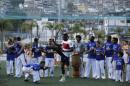 England national soccer team player Danny Welbeck, center, joins in a Capoeira dance demonstration with locals during a visit by a five England players to the Rocinha Sports Complex on the edge of the Rocina favela in Rio de Janeiro, Brazil, Monday June 9, 2014. The England soccer team are staying in Rio de Janeiro as their base city for the 2014 soccer World Cup. (AP Photo/Matt Dunham)