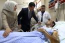 Turkish Prime Minister Ahmet Davutoglu and his wife Sare Davutoglu speak with a man who was injured in a blast in Suruc on Monday, during a visit to a hospital in Sanliurfa, Turkey, Tuesday, July 21, 2015. Authorities suspected the Islamic State group was behind an apparent suicide bombing Monday in Suruc in southeastern Turkey that killed 31 people and wounded nearly 100 — a development that could represent a major expansion by the extremists at a time when the government is stepping up efforts against them. (Halil Sagirkaya/Pool Photo via AP)