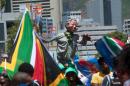 People wave South African flags next to a giant puppet of late South African former president Nelson Mandela in Cape Town on December 16, 201