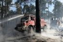 Firefighters tend to a wildfire in Pessac, southwest France on July 26, 2015