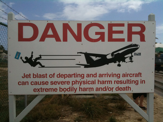 A sign posted on a nearby fence reveals the dangers of plane-spotting. (Photo: John Niedermeyer/Flickr)