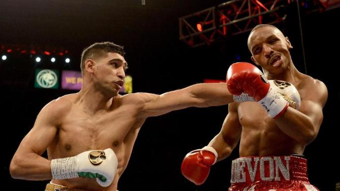 Amir Khan (L) hits Devon Alexander during their welterweight bout at the MGM Grand Garden Arena on December 13, 2014 in Las Vegas