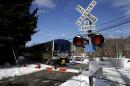 A train passes through the intersection where an SUV was struck by a Metro-North Railroad train in Valhalla, N.Y., Thursday, Feb. 5, 2015. An investigation into what caused a fiery crash that killed a motorist and five rail riders is focusing on how a mother of three described by friends as safety conscious ended up between two crossing gates in her SUV as a commuter train barreled toward her. (AP Photo/Seth Wenig)