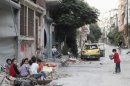 Children play along street in Homs