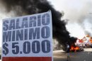 A placard that reads "A minimum $ 5,000 wage" is seen while demonstrators block the Pueyrredon Bridge, during a one-day nationwide strike in Buenos Aires