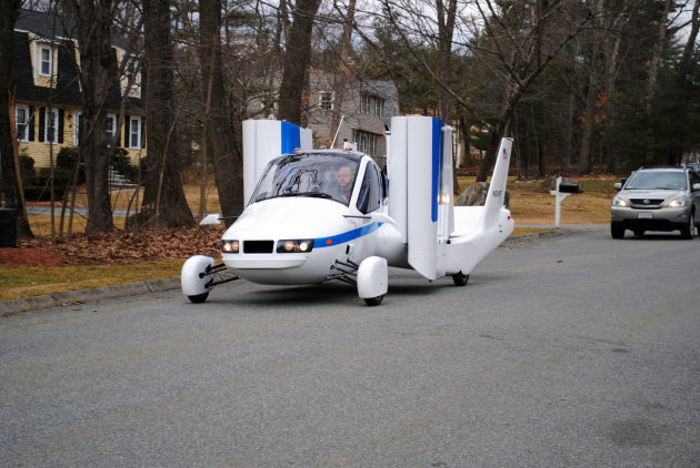 In this undated photo provided by Terrafugia Inc., the company's prototype flying car, dubbed the Transition, travels down a street with its wings folded.  The vehicle has two seats, four wheels and w