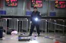 A Chinese police investigator inspects the scene of an attack at the railway station in Kunming, southwest China's Yunnan province, on March 2, 2014