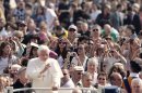 Pope Benedict XVI, foreground, is photographed by the faithful as he tours St. Peter's square during the weekly general audience at the Vatican, Wednesday, April 4, 2012. (AP Photo/Gregorio Borgia)