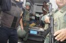 Soldiers prepare to evacuate unidentified injured victims during an uprising at Centro Occidental (Uribana) prison in Barquisimeto