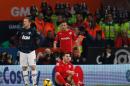 Manchester United's English striker Wayne Rooney (L) stands next to Cardiff City's English midfielder Jordon Mutch (R, down) after an early challenge that earned Rooney a yellow card at Cardiff City Stadium on November 24, 2013