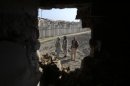 Afghan men are seen through hole caused by rocket attack in Kabul
