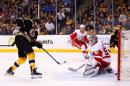 Milan Lucic (L) of the Boston Bruins scores a goal past Jonas Gustavsson of the Detroit Red Wings in the third period in Game Five of the first round of the 2014 NHL Stanley Cup Playoffs at TD Garden on April 26, 2014 in Boston, Massachusetts