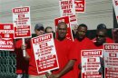 Detroit firefighters hold signs during a picket about the downsizing of the fire department outside the federal courthouse during day one of Detroit's municipal bankruptcy hearings in Detroit