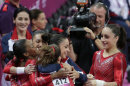 U.S. gymnasts celebrate after their routine on the vault during the Artistic Gymnastic women's team final at the 2012 Summer Olympics, Tuesday, July 31, 2012, in London. (AP Photo/Gregory Bull)