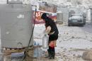 A Syrian refugee carries bread and bottles of water during a winter storm in Zahle town, in the Bekaa Valley