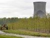 FILE - In this May 18, 2011 file photo, a worker  is seen in the area surrounding a tree farm in North Perry, Ohio, near the two cooling towers of the Perry Nuclear Power Plant looming in the background. The risk of an earthquake causing a severe accident at a nuclear power plant is up to 24 times greater than previously believed, according to an AP analysis of preliminary government data, and the nation’s nuclear regulator believes that a quarter of reactors may need modifications to make them safer. The Nuclear Regulatory Commission says more than two dozen plants in the eastern and central U.S. may need upgrades because they're more likely to get hit with an earthquake larger than the one their design was based on. It's a belated conclusion; for more than a decade, regulators ignored the evidence of increased quake risks.  (AP Photo/Amy Sancetta, File)