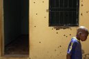 A boy looks at bullet holes in a compound where two hostages were held in Sokoto, Nigeria on Friday, March 9, 2012. A British and an Italian hostage were killed Thursday in Sokoto during a failed rescue mission by British special forces and the Nigerian military. A group that claimed ties to al-Qaida claimed the kidnapping, which happened in May 2011. (AP Photos/Jon Gambrell)