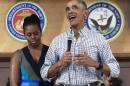 President Barack Obama, joined by first lady Michelle Obama, speaks during an event to thank service members and their families at Marine Corps Base Hawaii, in Kaneohe Bay, Hawaii, Sunday, Dec. 25, 2016. (AP Photo/Carolyn Kaster)