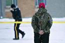A man holds a rosary as police investigate the scene of a shooting at the community school in La Loche, Saskatchewan, on Saturday, Jan. 23, 2016. The shooting took place on Friday. Saturday, Jan. 23, 2016. (Jason Franson/The Canadian Press via AP)
