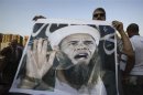 A protester who is against former Egyptian President Mohamed Mursi holds a poster of U.S. President Barack Obama sporting a beard during a protest at Tahrir square in Cairo