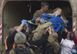 A wounded Israeli soldier is brought to a soccer field …