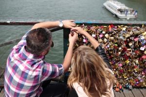 A couple locks a padlock on the "Pont des Arts" …