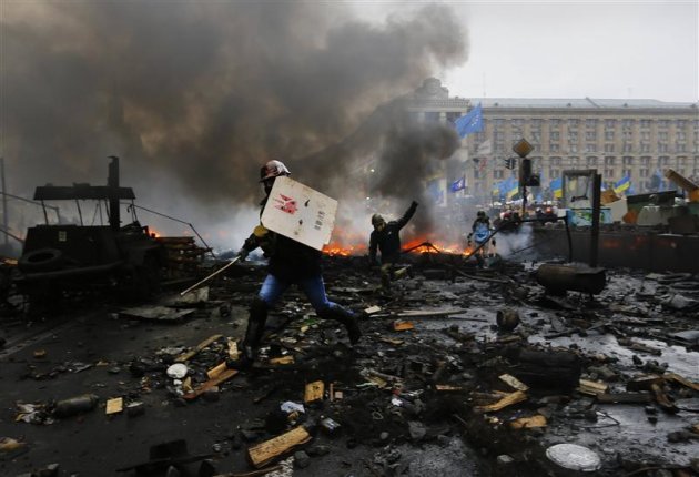 Les manifestants hostiles au président ukrainien Viktor Ianoukovitch ont repris jeudi le contrôle de la place de l'Indépendance à Kiev après de nouveaux affrontements avec la police anti-émeutes à l'issue desquels des corps recouverts de couvertures gisaient à même le sol. /Photo prise le 20 février 2014/REUTERS/Yannis Behrakis