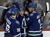 Vancouver Canucks Schroeder is congratulated by teammates Hansen and Raymond after scoring his second goal of night during NHL hockey in Vancouver