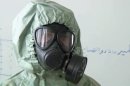 This image made from an AP video posted on Wednesday, Sept. 18, 2013 shows a student wearing a gas mask and protective suit during a classroom session a on how to respond to a chemical weapons attack in Aleppo, Syria. In a disused classroom of a school in the northern Syrian city of Aleppo, a group of volunteers learned how to deal with a chemical weapons attack. The drills came amid continued diplomatic wrangling over how to collect Syria's arsenal of chemical and biological agents to prevent any repeat of the August 21 attack outside Damascus that, according to the US, was carried out by Syrian regime and killed more than 1,400 people, including at least 400 children. (AP Photo via AP video)