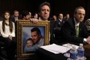 Neil Heslin, holds a picture of himself and his 6-year-old son, Newtown victim Jesse Lewis, during Senate Judiciary Committee hearing on the Assault Weapons Ban of 2013 in Washington