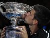 Djokovic of Serbia kisses his trophy after defeating Nadal of Spain in their men's singles final match at the Australian Open in Melbourne