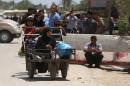 In this Saturday, May 16, 2015 photo, Iraqis fleeing from their hometown of Ramadi walk on a street near the Bzebiz bridge, 65 kilometers (40 miles) west of Baghdad. Muhannad Haimour, a spokesman for the governor of Iraq's Anbar province, said Sunday, "Ramadi has fallen," to the Islamic State group. He also said the military's operational command in the city has been taken as well. (AP Photo/Hadi Mizban)