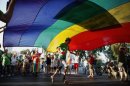 Israelis carry a rainbow coloured flag as they participate in the 10th anniversary Gay Pride Parade